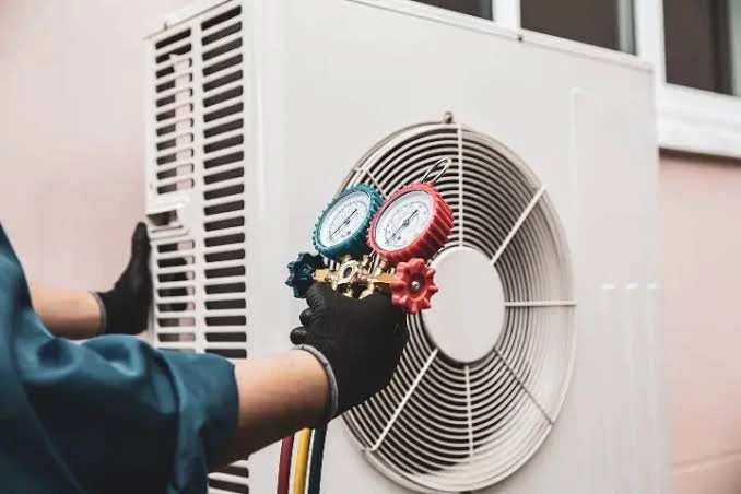Pressure gauges being used to check an outdoor cooling system